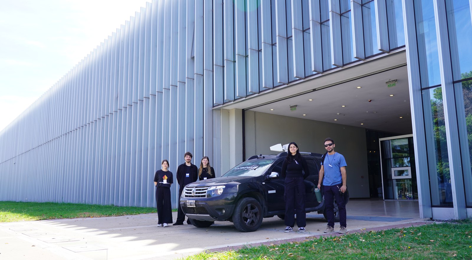 Marsupial RF team and test vehicle outside a large building.